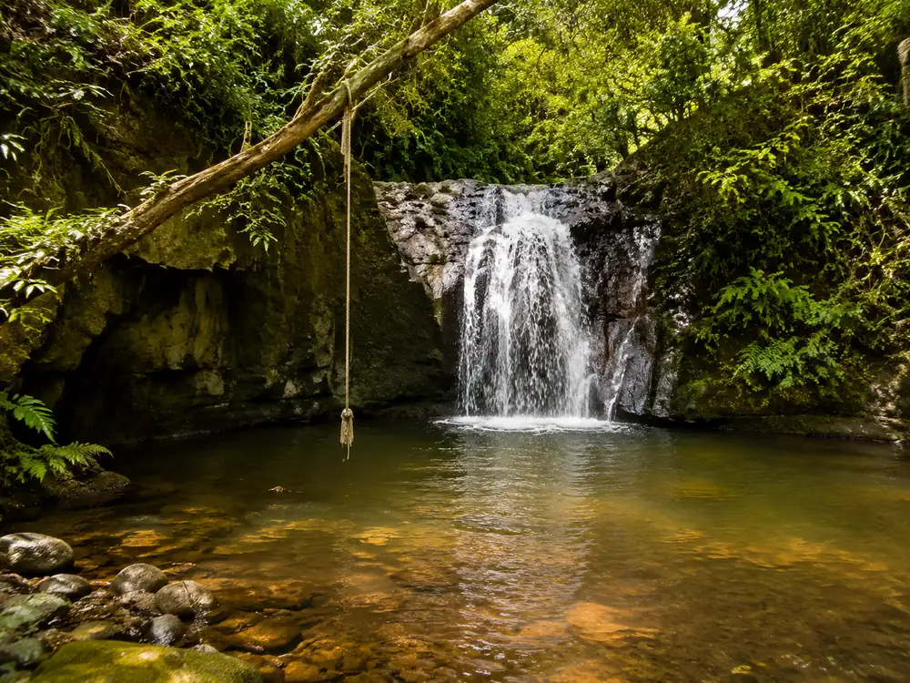 La segunda cascada más pequeña río arriba, con la cuerda para columpiarse en la orilla izquierda